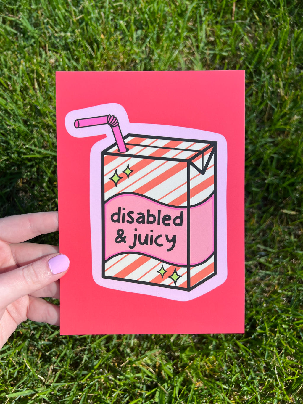 Art print with bright coral background with juice box in the center outlined in light pink. Juice box is cream with orange diagonal stripes and pink banner in the middle with yellow sparkles in either side. A pink straw is coming from the top. The black font on the juice box reads, "disabled and juicy". 